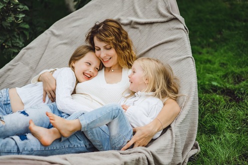 Exhausted mother with children - homeopathic support for postpartum recovery and burnout.